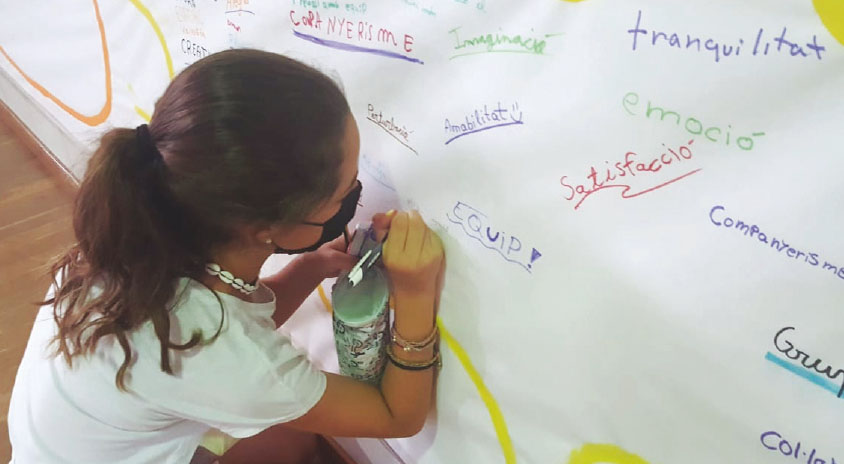 Niños y niñas escribiendo en el mural de las sensaciones al terminar de ver la exposición