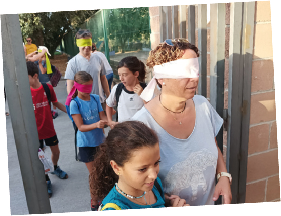 El primer día de escuela, los niños y niñas vendaban los ojos del los padres y las madres y les guiaban siguiendo objetivos por todo el espacio escolar hasta llegar al patio