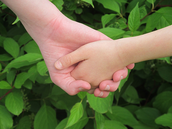 Imagen de dos niños cogidos de la mano 