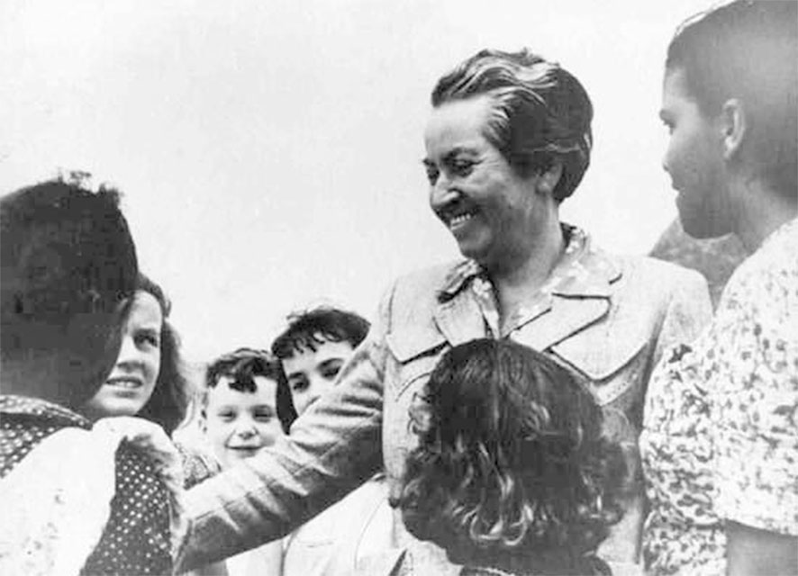 Gabriela Mistral rodeada de niños