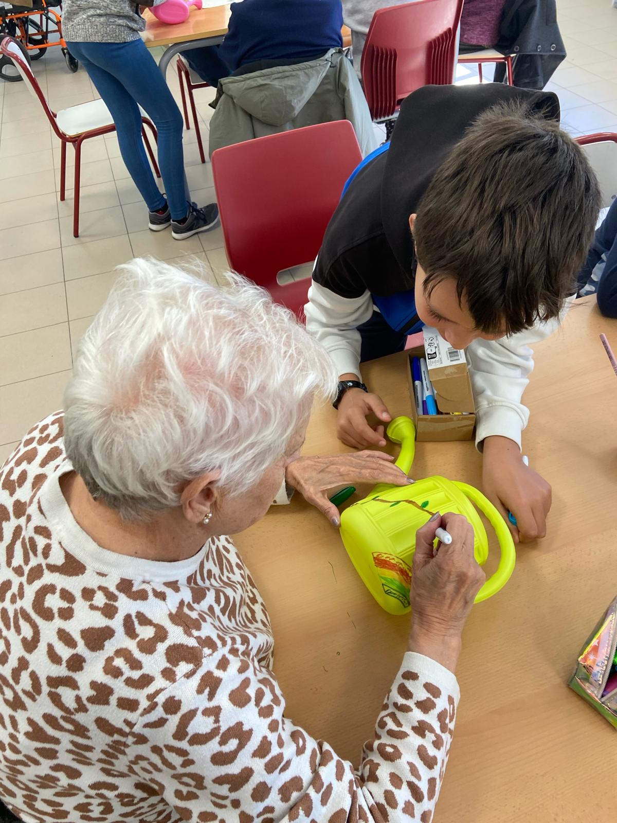 Imagen de una persona mayor interactuando con un alumno de primaria