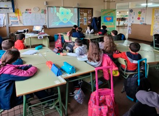 Imagen de una clase con el alumnado mirando un vídeo en el proyector