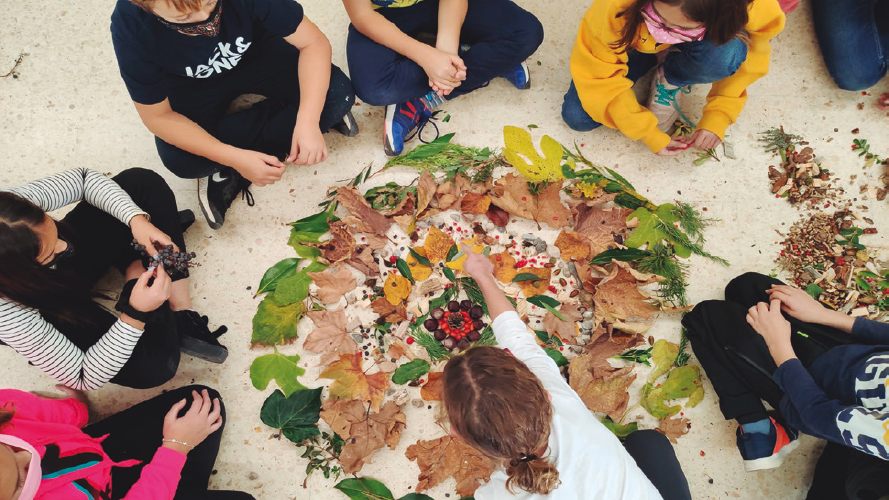 Alumnes del cicle superior de primària de l’escola Alfred Mata, de Puig-reig, fent un mandala amb fulles de tardor